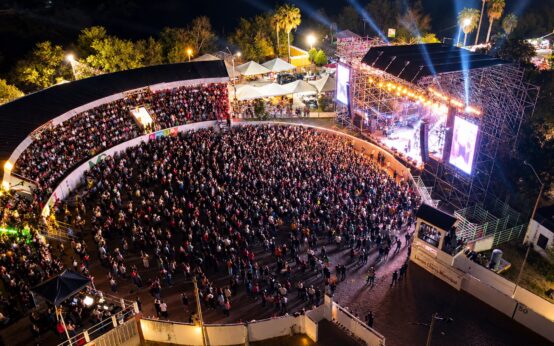 Vista panorámica del Lienzo Charro Félix Cárdenas con público en las gradas y frente al escenario iluminado durante las Fiestas Patrias.
