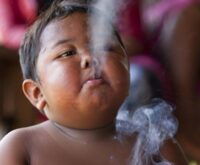 Ardi Rizal cuando era pequeño, con un cigarrillo en la boca y humo frente al rostro, imagen de archivo del caso de Indonesia
