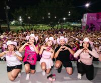Asistentes a Corre Corazón 2.5 KM reunidos por la noche y haciendo corazones con las manos en Ciénega de Flores
