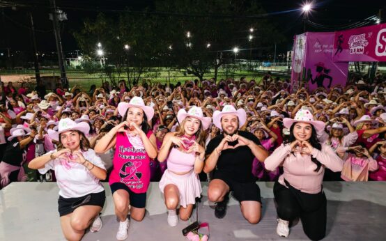 Asistentes a Corre Corazón 2.5 KM reunidos por la noche y haciendo corazones con las manos en Ciénega de Flores