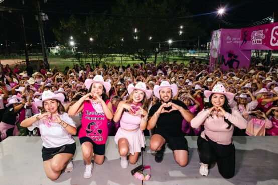 Asistentes a Corre Corazón 2.5 KM reunidos por la noche y haciendo corazones con las manos en Ciénega de Flores