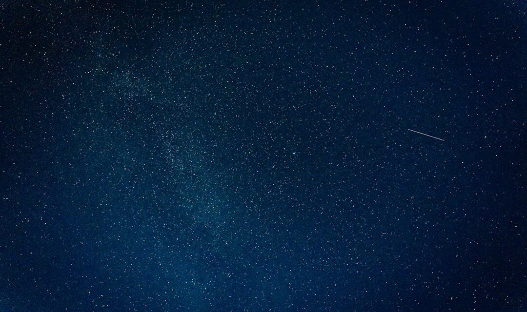 Estrella fugaz cruzando un cielo nocturno estrellado, imagen ilustrativa