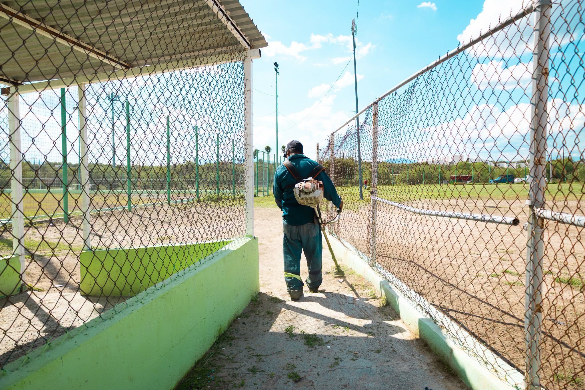 Trabajador recorre un espacio deportivo durante labores de limpieza y mantenimiento en Ciénega de Flores