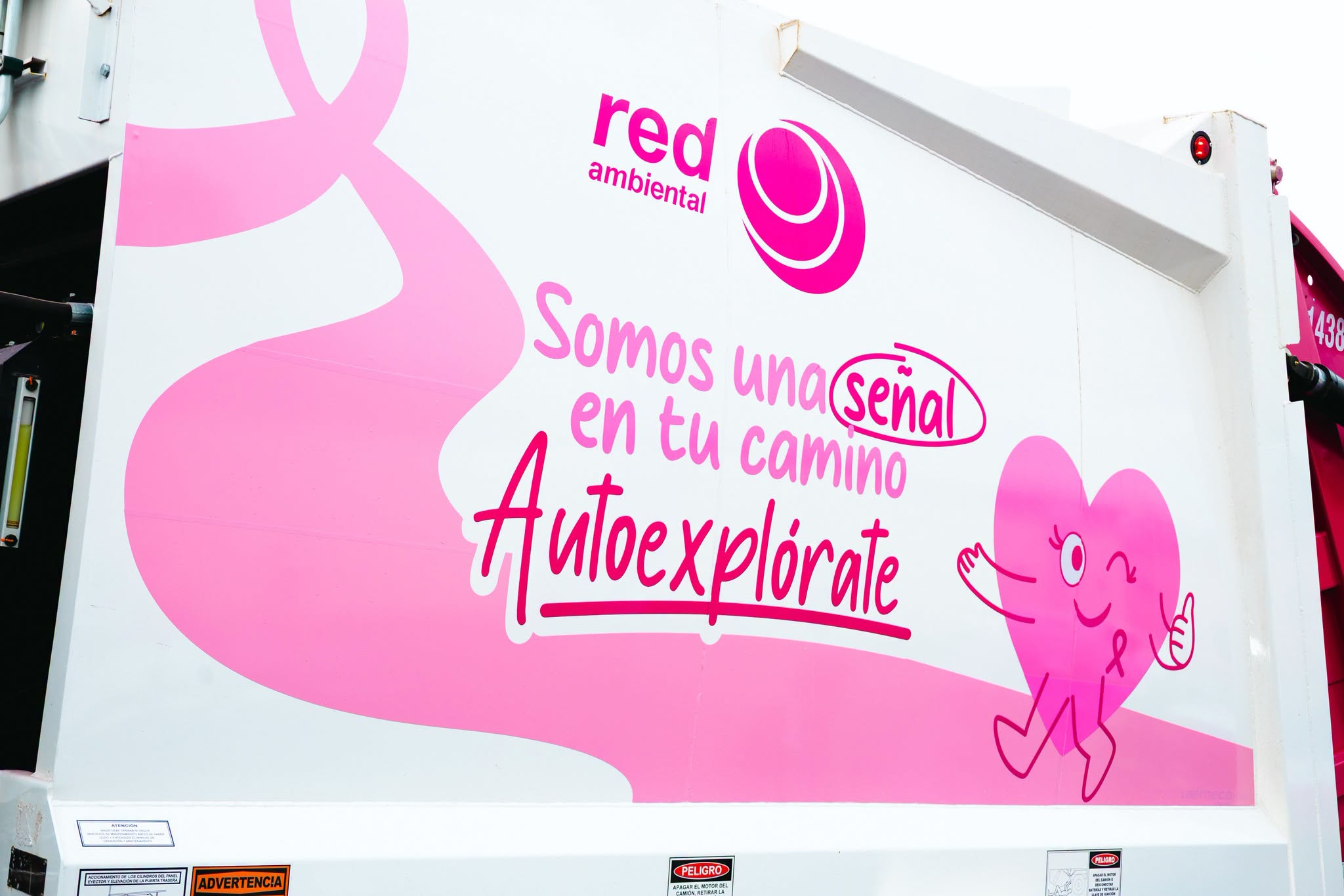 Detalle de mensaje de autoexploración y lazo rosa en camión Red Ambiental