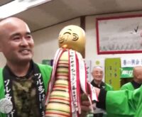 Dos hombres sonrientes con chaquetas verdes durante una celebración del club de Tsuruta