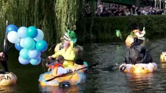 Personas disfrazadas dentro de calabazas que flotan en un estanque