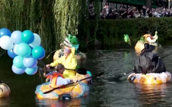 Personas disfrazadas dentro de calabazas que flotan en un estanque