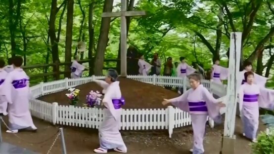 Personas con vestimenta ceremonial frente a un recinto con cruces en Shingo