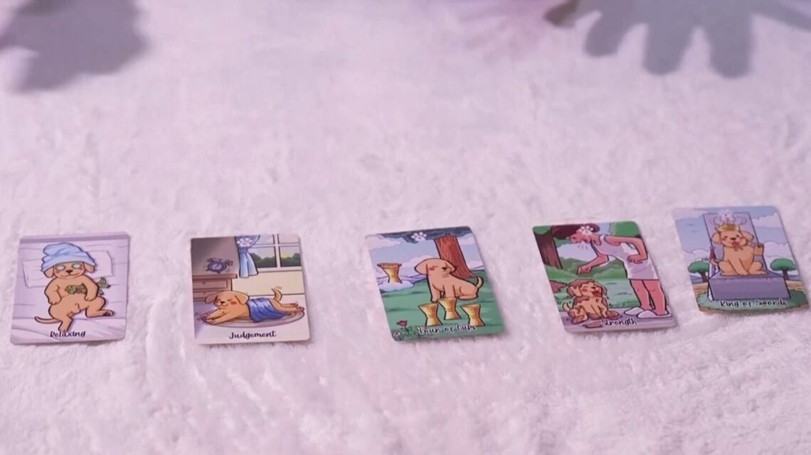 Cinco cartas de tarot con dibujos de perros sobre una mesa